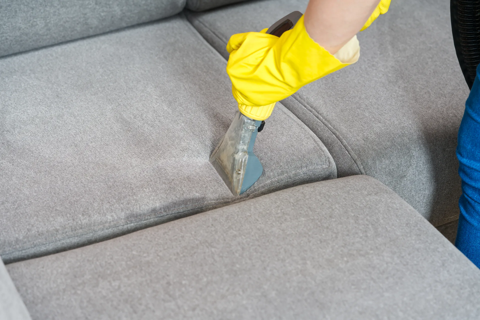 An upholstery tool running across the cushion of a grey sofa