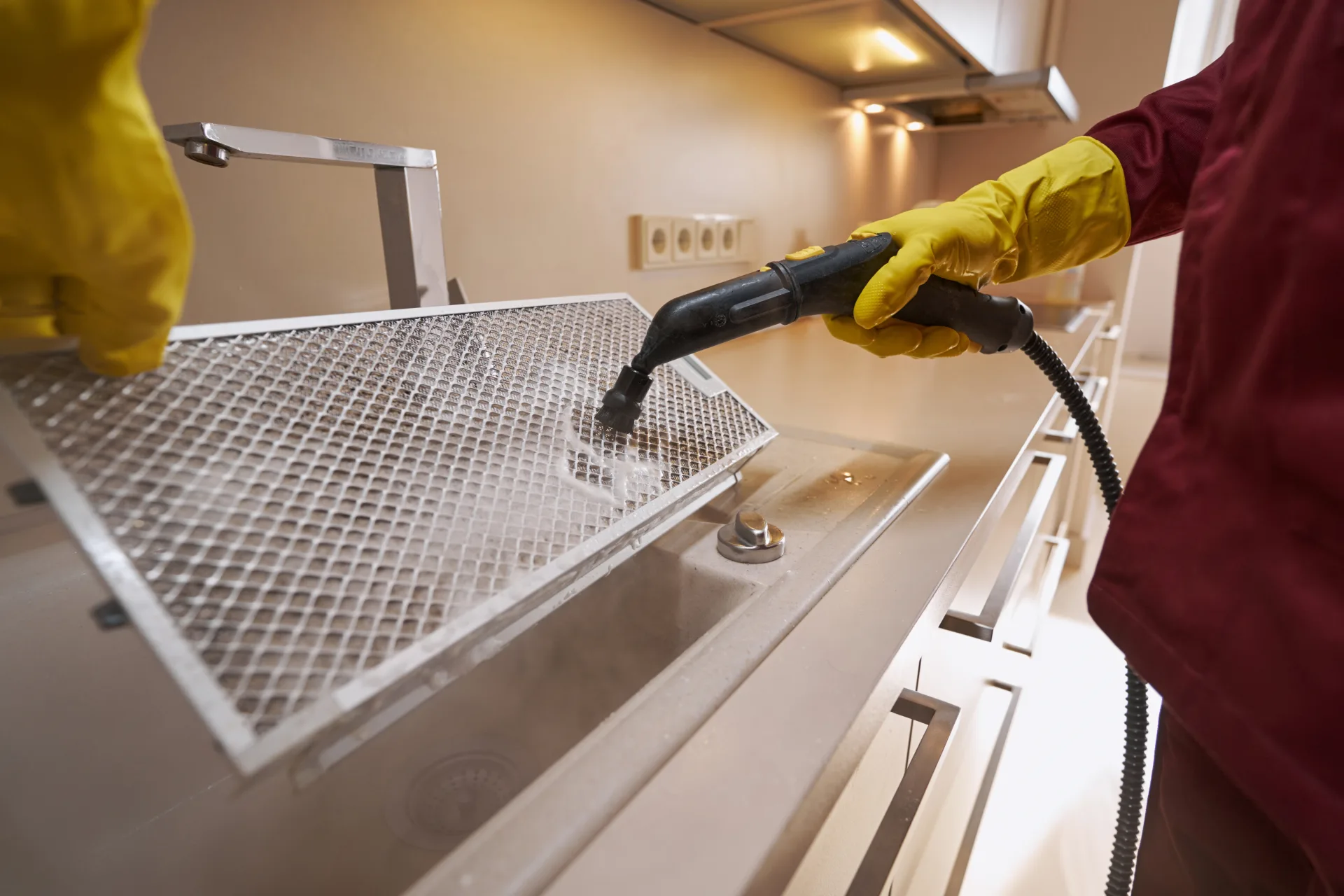 Steam-cleaning the metal filter out of a kitchen range hood
