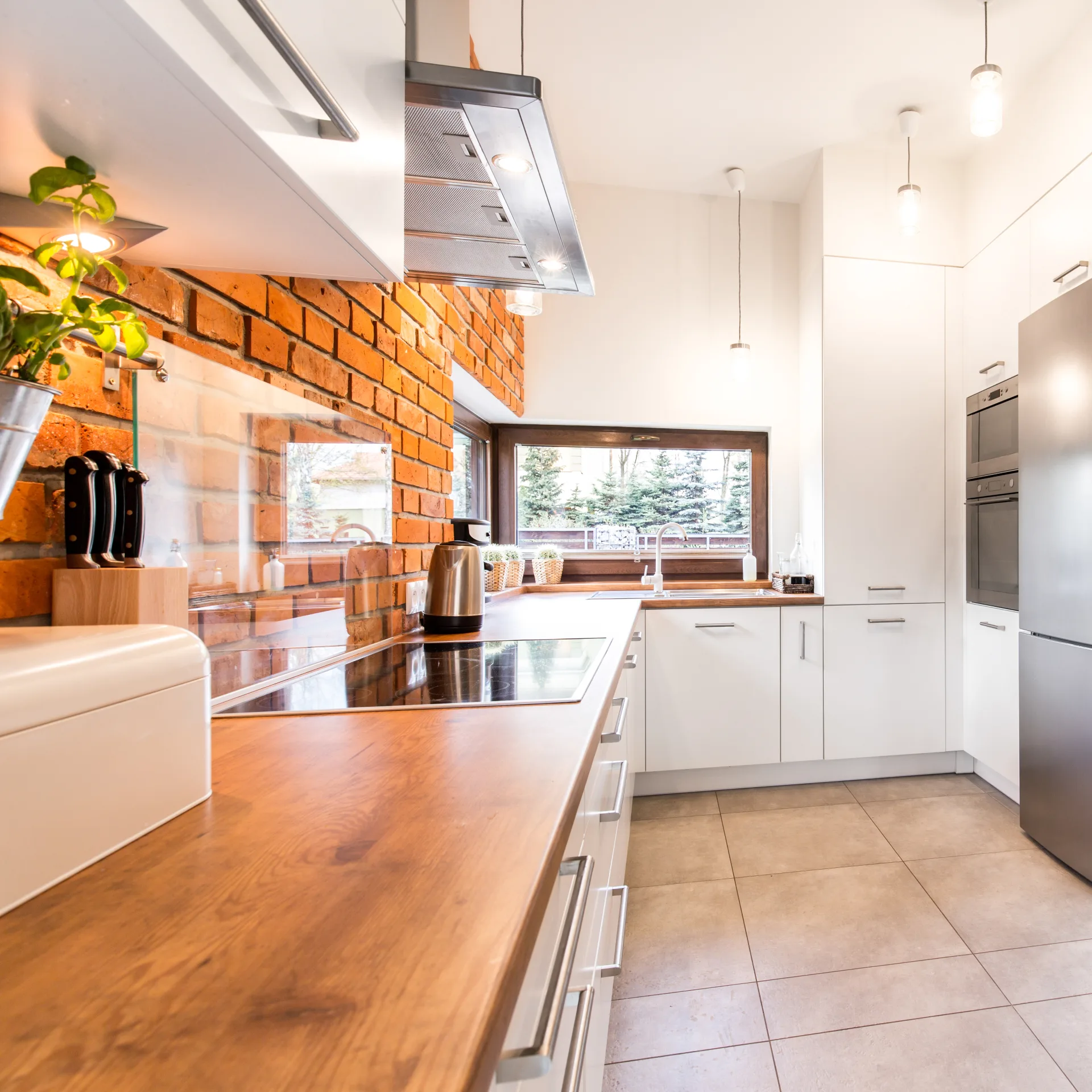 A kitchen with a wooden worktop and exposed brick, wiped down and clear